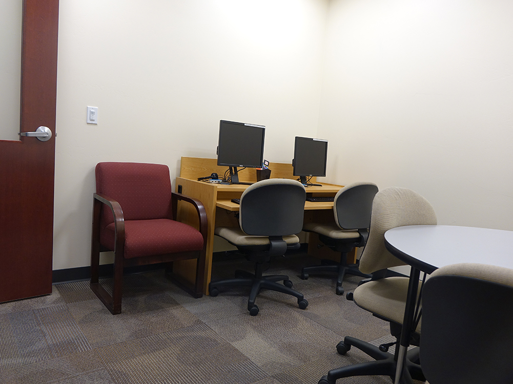 East Study Room equipped with a round table, chairs, and two desktop computers