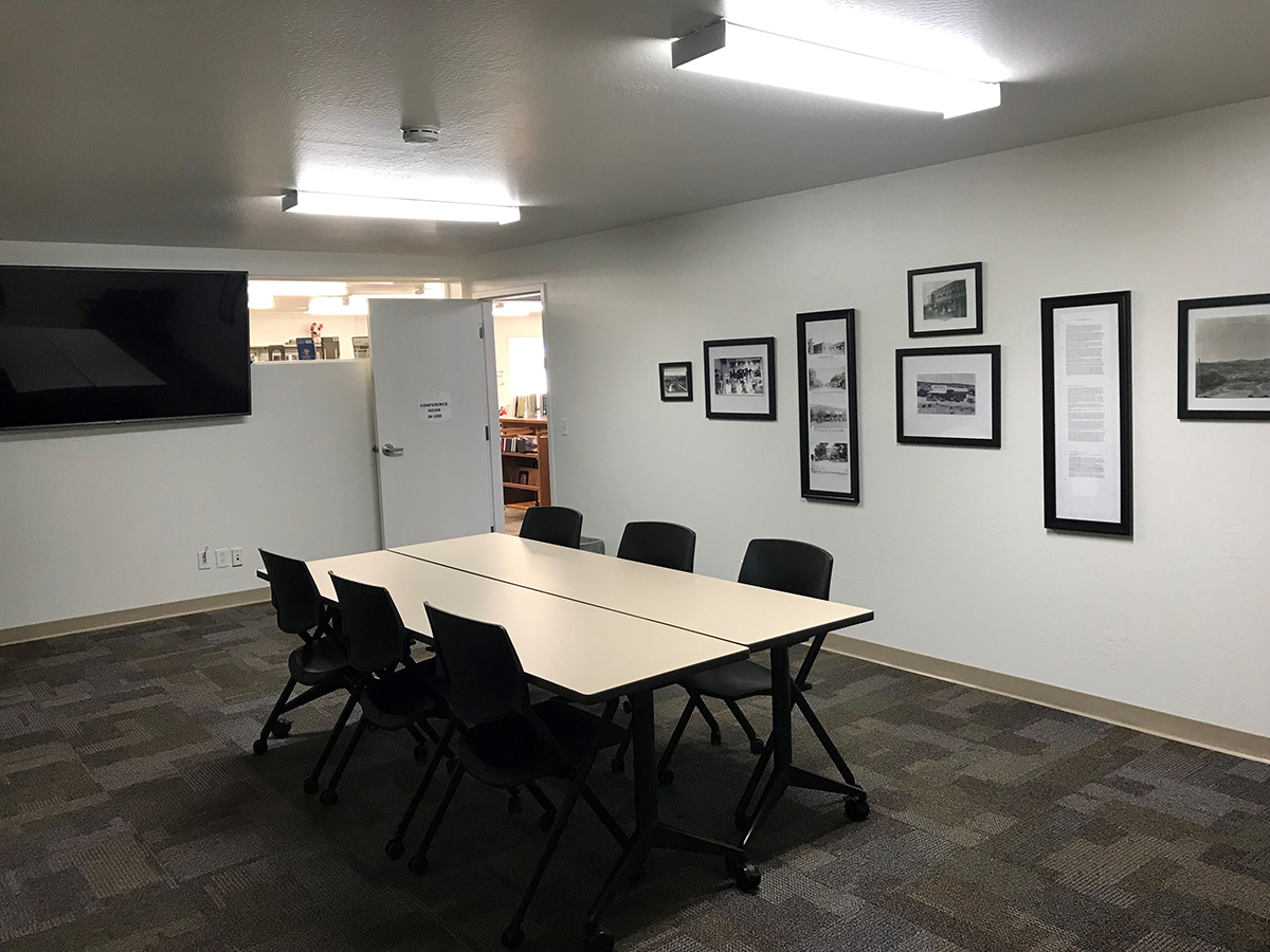 Mayer Meeting room with central conference table, 6 chairs, and a large tv mounted on to wall