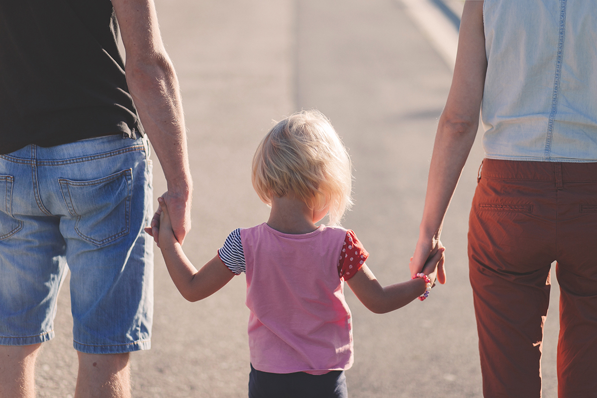 Parents walking hand in hand with child