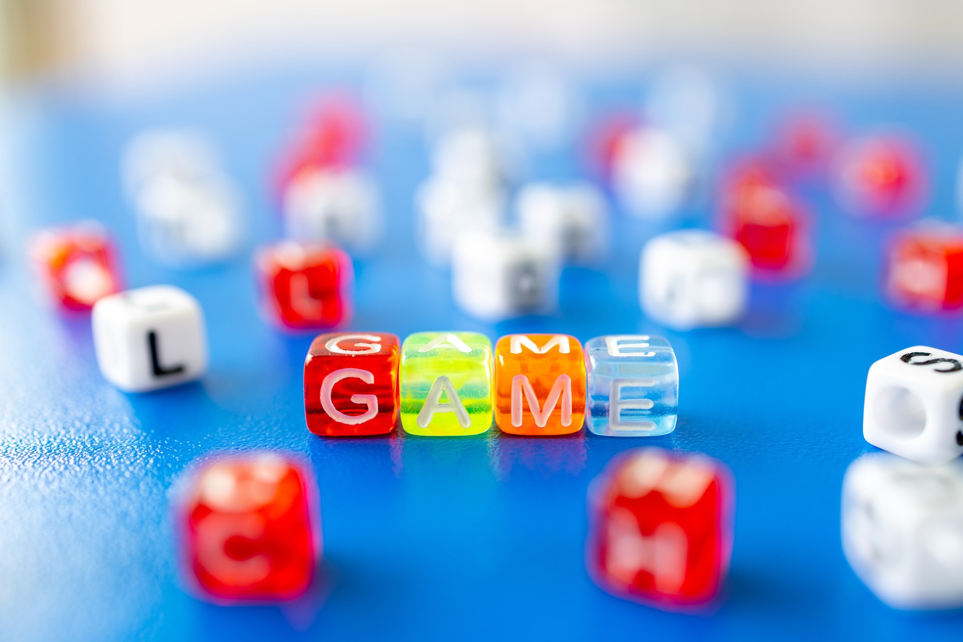 Letter dice spelling out the word "GAME".