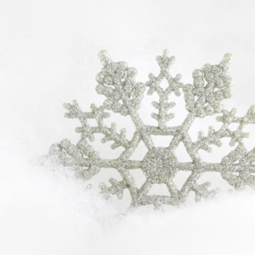 Image of snowflake ornament in snow.