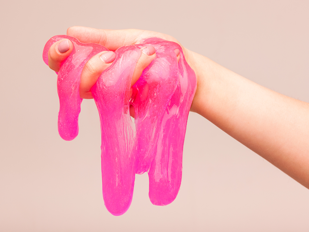 hand holding dripping pink slime