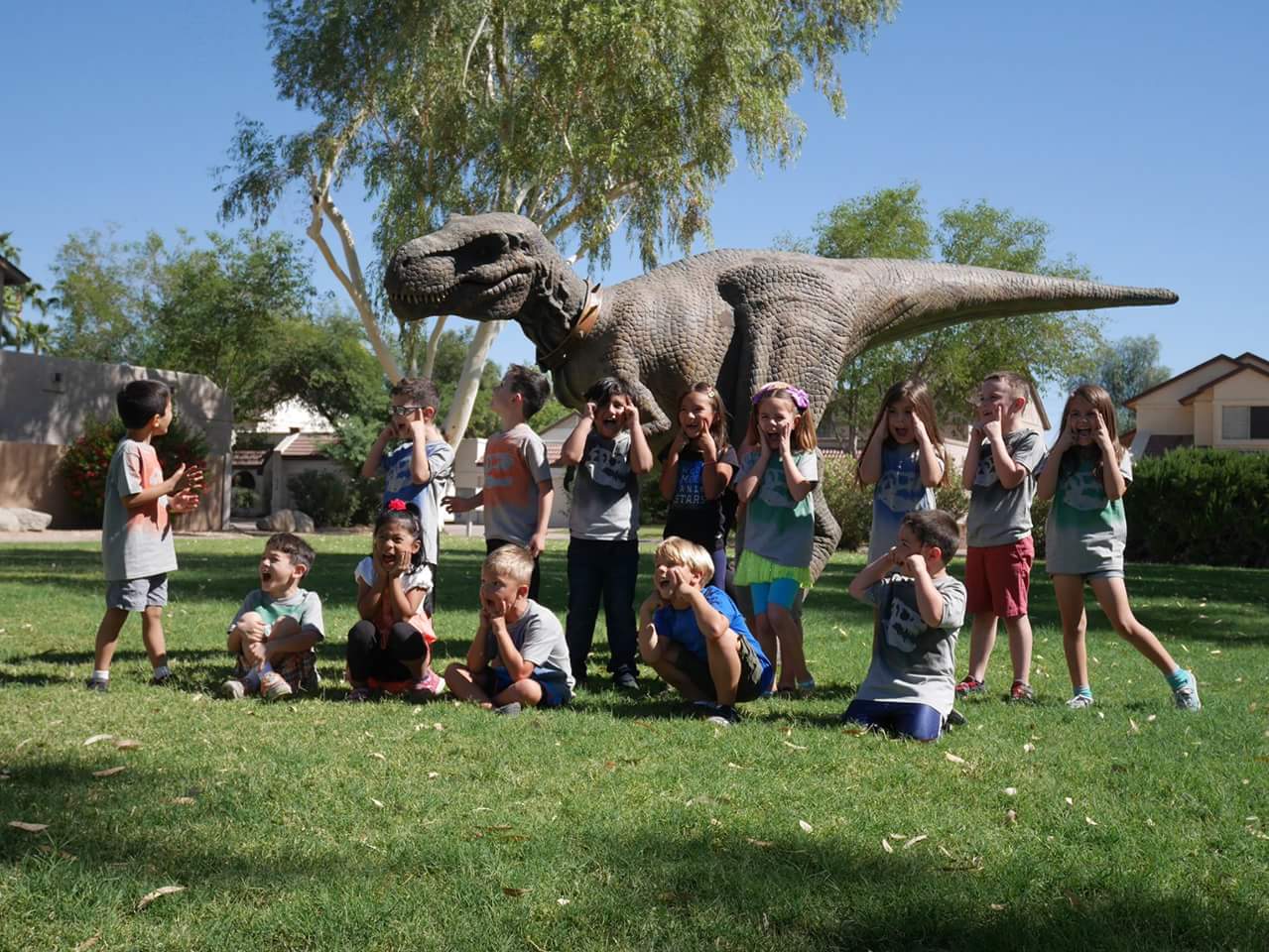 kids standing in front of a lifesize animatronic dinosaur
