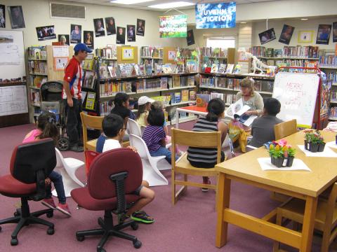 Librarian reading to a group of children and parents