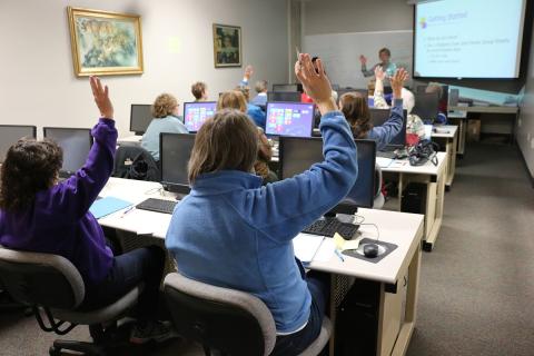 Woman giving a technology presentation to people in a computer lab