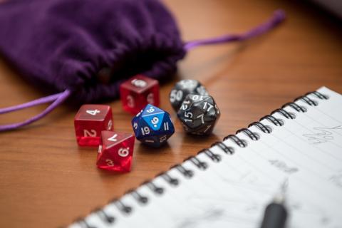 Set of pen, notebook, and polyhedral dice for playing role-playing games.