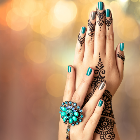 Photo of A woman's hands with Henna painted on them.