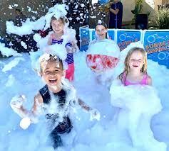 four kids covered in bubbles