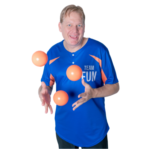 smiling man wearing a blue shirt and juggling three orange balls