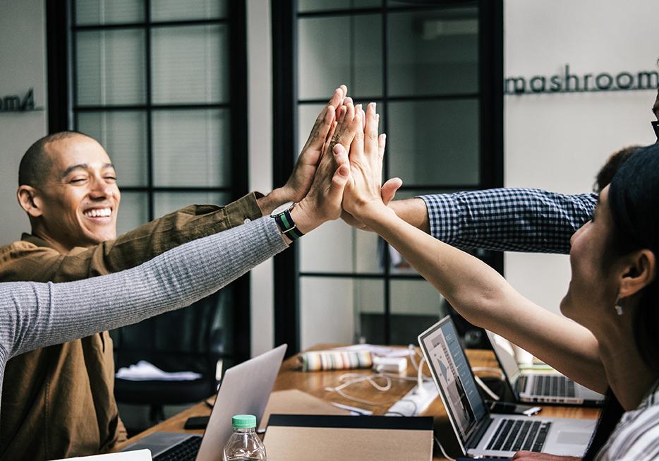 Four people high-fiving