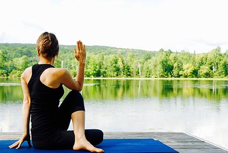 Woman doing yoga by water