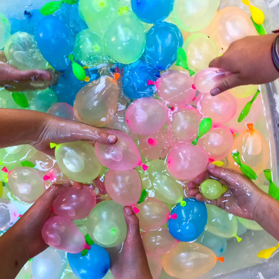 Picture of people grabbing water balloons.