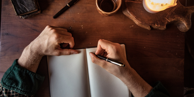 hands writing in a journal