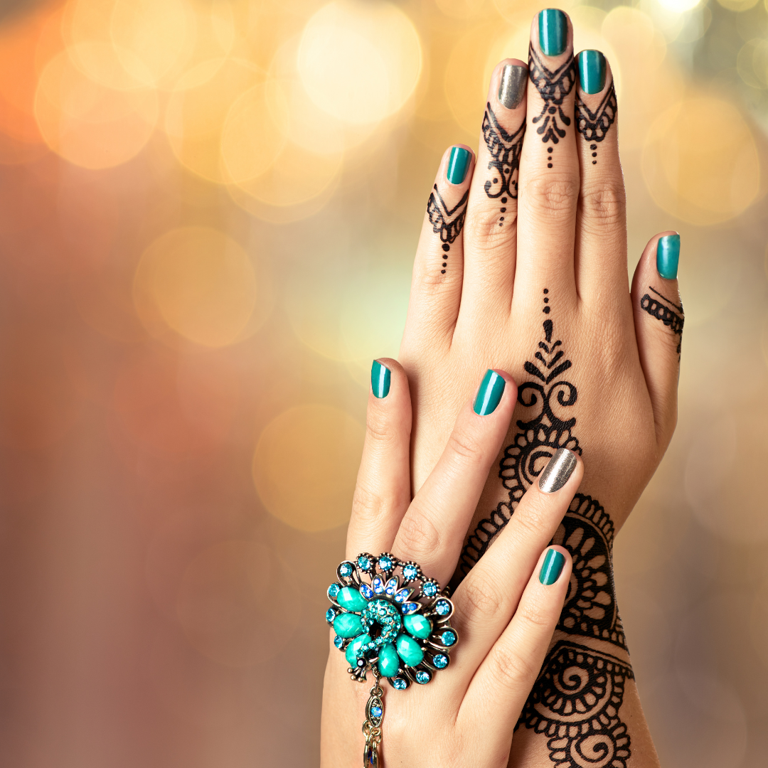 Photo of A woman's hands with Henna painted on them.