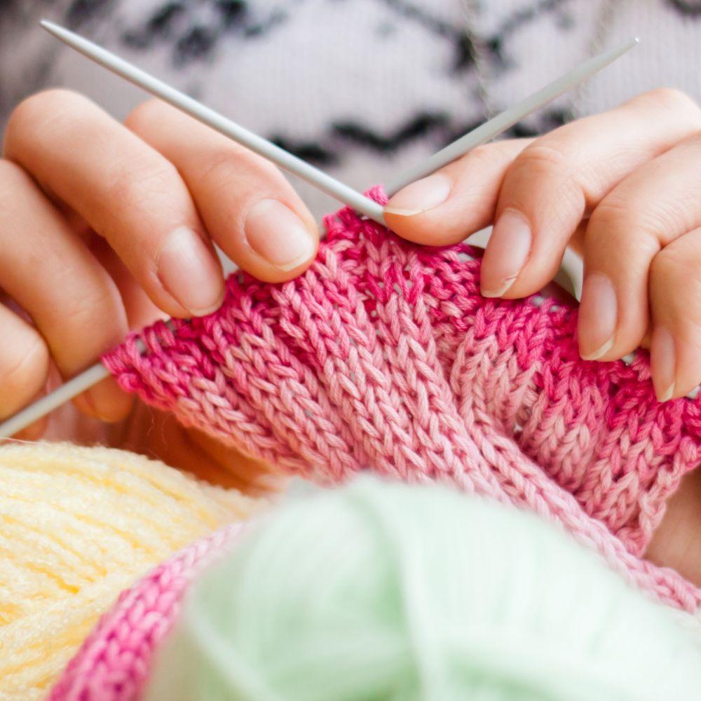 Knitting with Diane, hands knitting with pink and green yarn